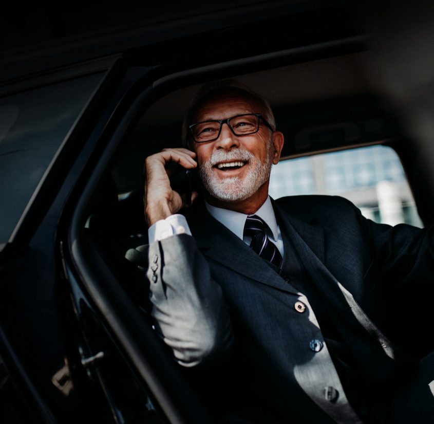 Man in suit smiling while on phone.