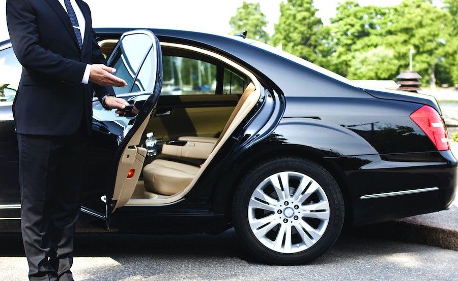 img-Transport-par-limousine (1) Chauffeur holding car door open.
