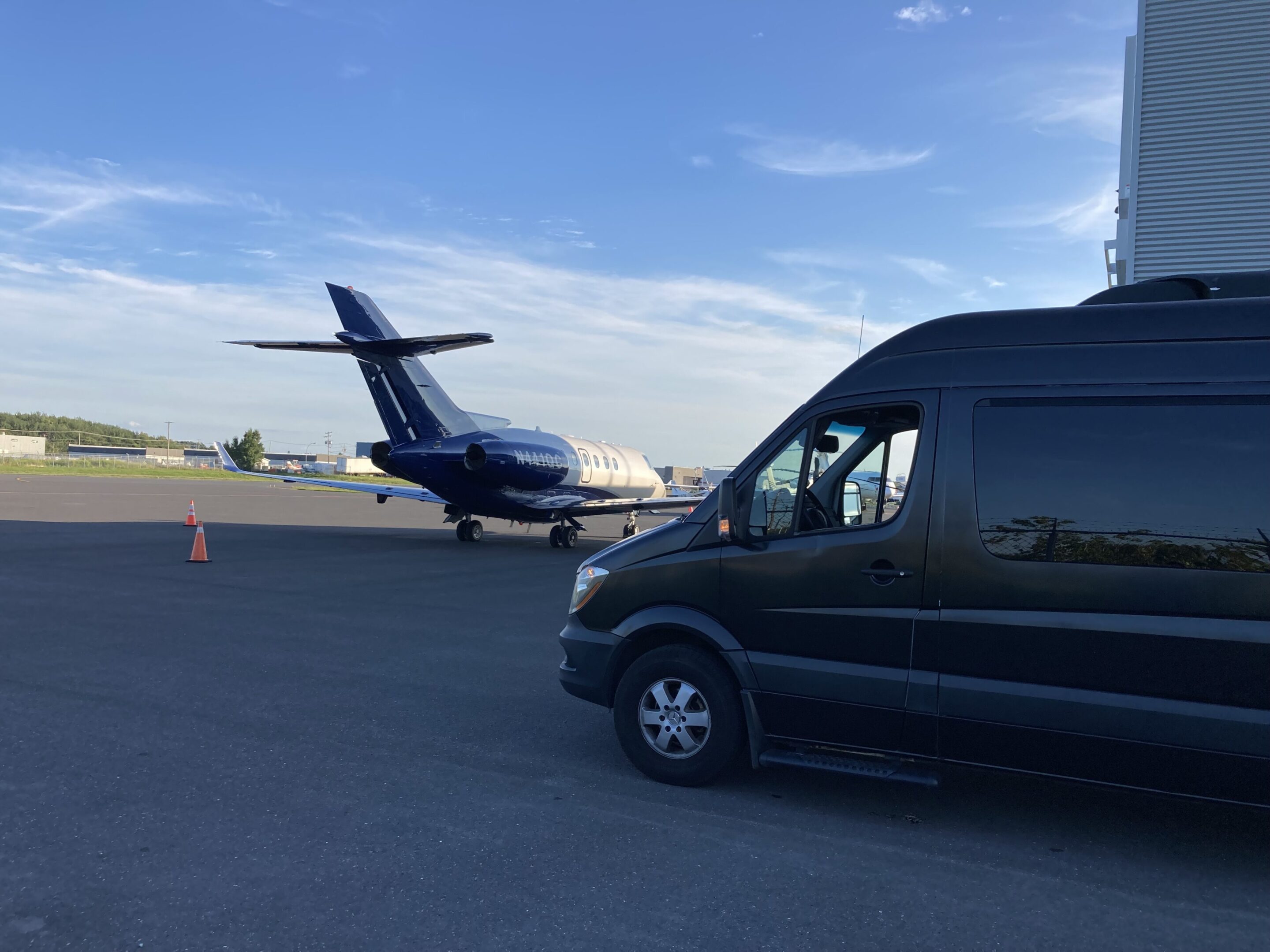 681248d8e745d_photo avjet sprinter A small airplane and a black van parked on an airport runway.